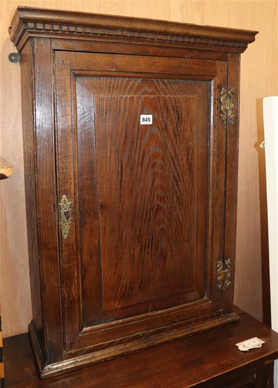 An 18th century oak hanging cupboard with fielded panelled door H.80cm